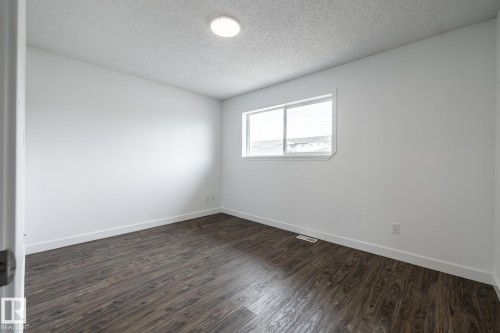 Room featuring wood-finish flooring, white baseboards, and a neutral color palette - #136, 180 Bridgeport Bv, Leduc, AB - Indoor Photo Showing Other Room