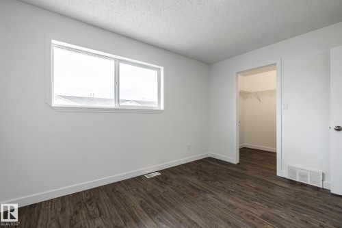 Bright interior space featuring wood-finish flooring, white baseboards, and a large window - #136, 180 Bridgeport Bv, Leduc, AB - Indoor Photo Showing Other Room