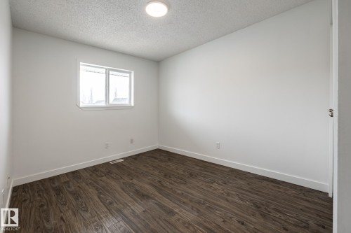 Room with wood-finish flooring, white walls, and a recessed window - #136, 180 Bridgeport Bv, Leduc, AB - Indoor Photo Showing Other Room