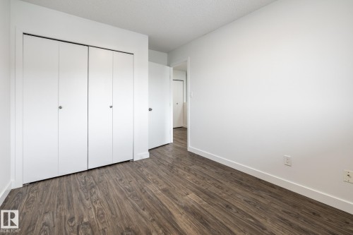 Room featuring wood-finish flooring, white walls, and bright white baseboards - #136, 180 Bridgeport Bv, Leduc, AB - Indoor Photo Showing Other Room