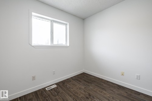 Room with wood-finish flooring, white walls, and a window with white trim - #136, 180 Bridgeport Bv, Leduc, AB - Indoor Photo Showing Other Room