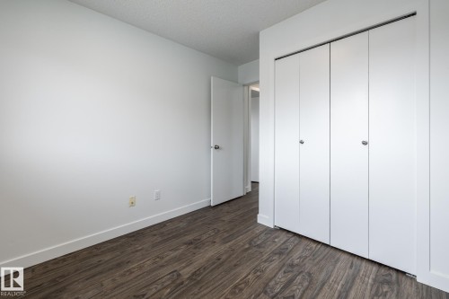 Room featuring wood-finish flooring, white walls, and bright white trim - #136, 180 Bridgeport Bv, Leduc, AB - Indoor Photo Showing Other Room