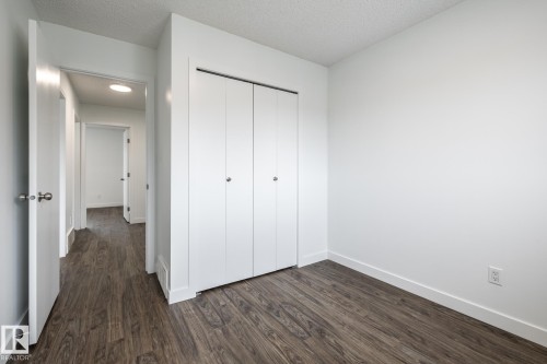 Room featuring wood-finish flooring, white walls, and bright white baseboards - #136, 180 Bridgeport Bv, Leduc, AB - Indoor Photo Showing Other Room