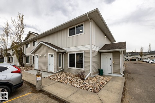 Multi-unit building exterior featuring light-toned siding and white trim - #136, 180 Bridgeport Bv, Leduc, AB - Outdoor