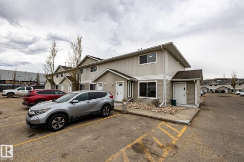 Two-story townhome with light-colored horizontal siding and dark shingle roofing - #136, 180 Bridgeport Bv, Leduc, AB - Outdoor