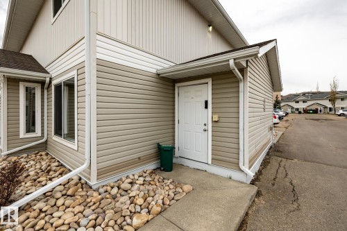 Exterior featuring horizontal siding, white trim, and a white entry door - #136, 180 Bridgeport Bv, Leduc, AB - Outdoor With Exterior