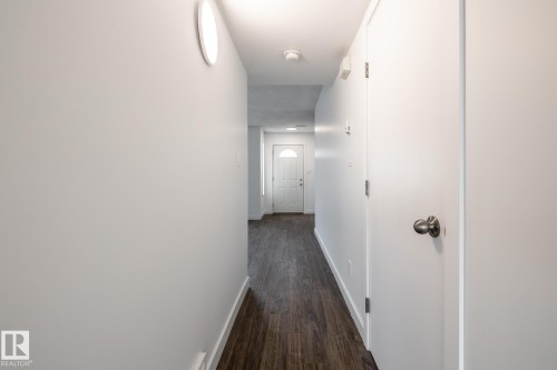 Hallway featuring wood-finish flooring, light neutral walls, and recessed lighting - #136, 180 Bridgeport Bv, Leduc, AB - Indoor Photo Showing Other Room