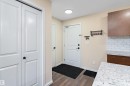 Entryway featuring wood-finish flooring, a white paneled door, and a built-in closet with bifold doors - 122 3357 16A Avenue, Edmonton, AB  - Indoor 