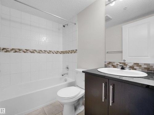 Bathroom featuring a white subway tile shower surround with an accent mosaic tile band - 220 5804 Mullen Place, Edmonton, AB - Indoor Photo Showing Bathroom