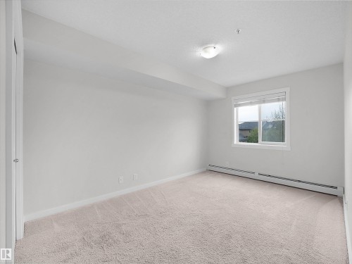 Neutral-toned carpeting throughout - 220 5804 Mullen Place, Edmonton, AB - Indoor Photo Showing Other Room