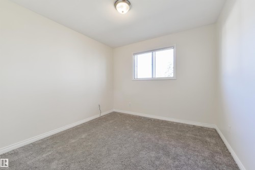 Room featuring light-colored walls, gray carpeting, white baseboards, and a single window with white trim - 6134 37A Avenue, Edmonton, AB 