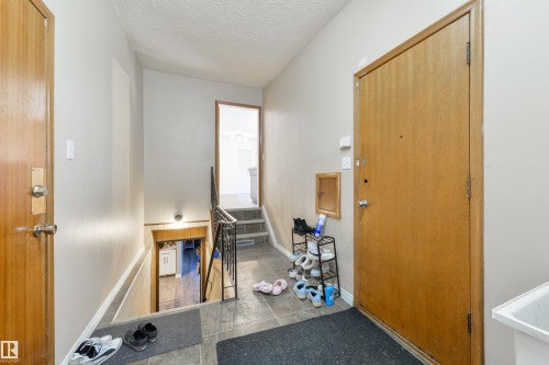 Entry area featuring tile flooring, neutral wall paint, and multiple access points to other areas of the property - 6134 37A Avenue, Edmonton, AB 