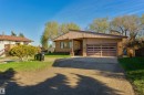 Single-story brick exterior featuring a multi-pane garage door, covered entryway, and asphalt driveway - 6134 37A Avenue, Edmonton, AB 