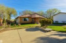 Brick and panel exterior with a prominent front window and a concrete driveway - 6134 37A Avenue, Edmonton, AB 