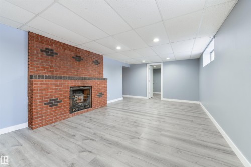 Brick fireplace with a black metal insert - 6134 37A Avenue, Edmonton, AB 