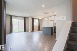 Open-concept living space featuring wood-finish flooring, recessed lighting, and a sliding glass door to the backyard - 