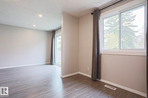 Spacious room featuring wood-finish flooring, recessed lighting, and a sliding glass door - 35 Chungo Drive, Devon, AB - Indoor Photo Showing Other Room
