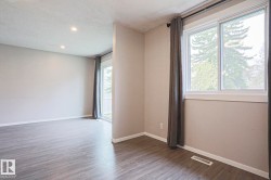 Spacious room featuring wood-finish flooring, recessed lighting, and a sliding glass door - 
