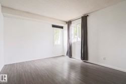 Bright interior space with wood-finish flooring, white walls, and two windows - 