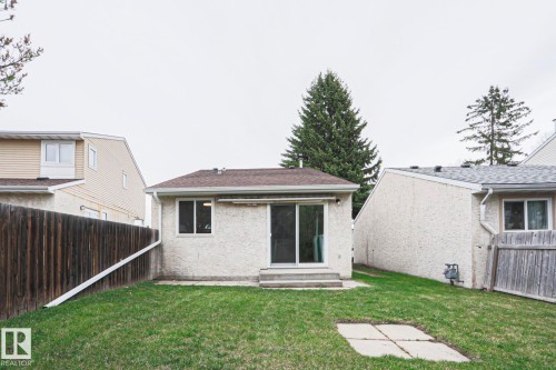Expansive green lawn with a brown privacy fence and mature trees - 35 Chungo Drive, Devon, AB - Outdoor