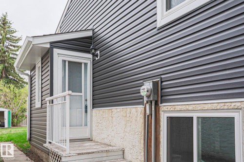 Dark gray horizontal siding with white trim, a covered entry, and a white screen door - 35 Chungo Drive, Devon, AB - Outdoor