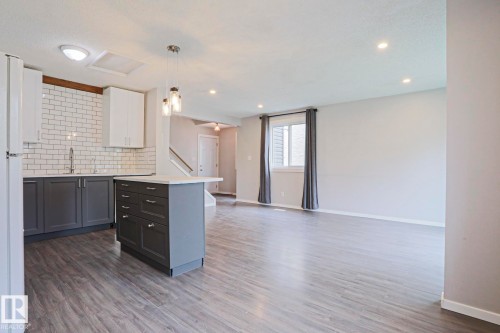 Open-concept living space featuring wood-finish flooring, recessed lighting, and a kitchen island with storage - 35 Chungo Drive, Devon, AB - Indoor Photo Showing Kitchen