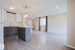Open-concept living space featuring wood-finish flooring, recessed lighting, and a kitchen island with storage - 