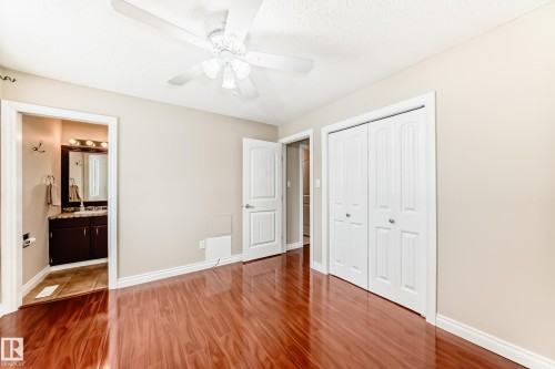 This room features polished wood flooring, a ceiling fan, and white bi-fold closet doors - 13332 25 Street, Edmonton, AB - Indoor Photo Showing Other Room
