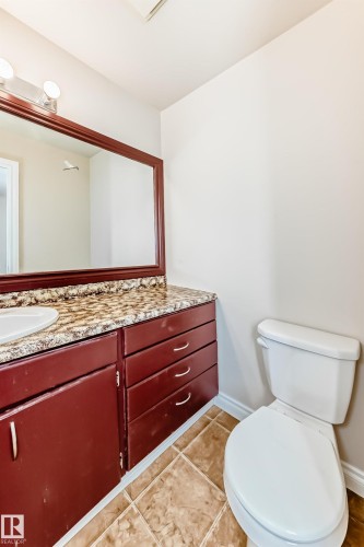 Bathroom featuring a vanity with a mirrored cabinet, a light fixture with three bulbs, and a toilet - 13332 25 Street, Edmonton, AB - Indoor Photo Showing Bathroom