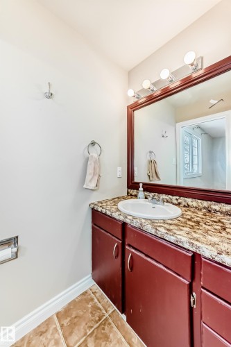 Bathroom featuring a vanity with a white oval sink, a granite countertop, and a large mirror with overhead lighting - 13332 25 Street, Edmonton, AB - Indoor Photo Showing Bathroom