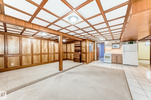 This space features wood paneling, a wood coffered ceiling, recessed lighting, and a white tile floor - 13332 25 Street, Edmonton, AB - Indoor