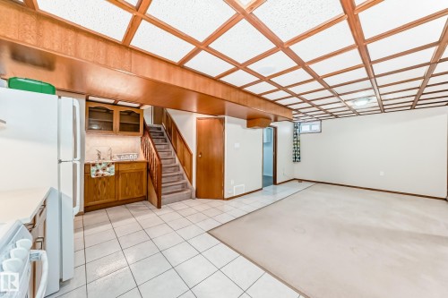 Spacious room featuring a coffered ceiling with wood trim, white tiled flooring, and a carpeted area - 13332 25 Street, Edmonton, AB - Indoor Photo Showing Other Room