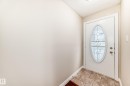 Entryway featuring a white door with an oval-shaped decorative glass insert, complemented by tiled flooring - 13332 25 Street, Edmonton, AB  - Indoor Photo Showing Other Room 