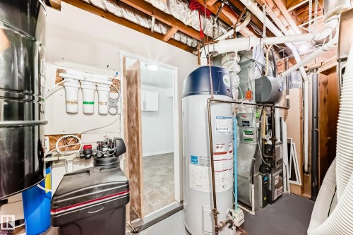 The property features a water heater, a water softener, a water filtration system, and exposed ceiling joists - 13332 25 Street, Edmonton, AB - Indoor Photo Showing Basement