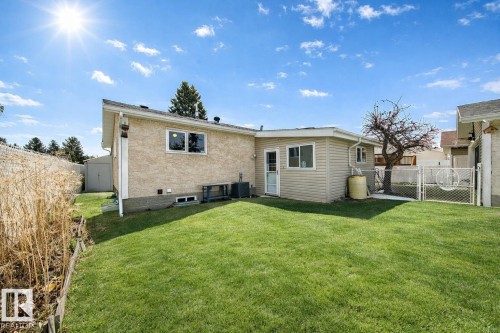 The property features a spacious rear yard with a well-maintained lawn and a shed for storage - 13332 25 Street, Edmonton, AB - Outdoor With Exterior