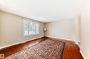 This room features hardwood flooring, a large window, and light-colored walls - 13332 25 Street, Edmonton, AB  - Indoor Photo Showing Other Room 