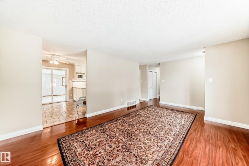 This living area features polished wood floors and light-colored walls - 13332 25 Street, Edmonton, AB - Indoor Photo Showing Other Room