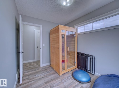 Room featuring wood-finish flooring, light grey walls, and white trim - 11 165 Cy Becker Boulevard, Edmonton, AB - Indoor