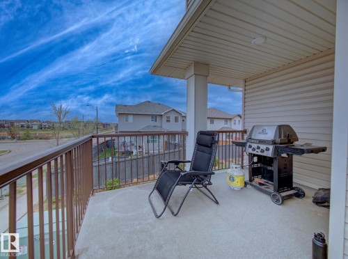 Private balcony featuring a concrete surface, protective railing, column support, and overhead soffit with recessed lighting - 11 165 Cy Becker Boulevard, Edmonton, AB - Outdoor With Deck Patio Veranda With Exterior