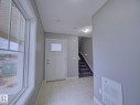 Entryway featuring a white paneled door with frosted glass, ceramic tile flooring, and a window with exterior views - 11 165 Cy Becker Boulevard, Edmonton, AB  - Indoor Photo Showing Other Room 