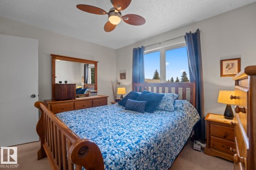 Bedroom featuring a large window, a ceiling fan with integrated lighting, and carpet flooring - 1304 12 Street, Cold Lake, AB - Indoor Photo Showing Bedroom