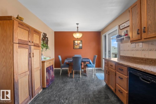 Spacious kitchen featuring wood cabinetry, stone-finish countertops, and a full-size dishwasher - 1304 12 Street, Cold Lake, AB - Indoor