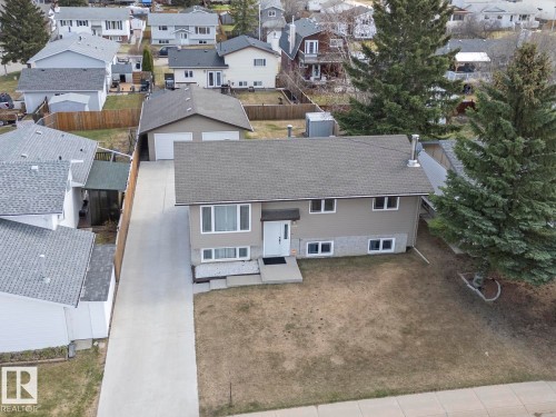 Bi-level residence featuring a neutral-toned exterior with stone veneer accents and a dark shingle roof - 1304 12 Street, Cold Lake, AB - Outdoor