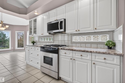 Kitchen featuring white cabinetry, stainless steel range, and stone-finish countertops - 201 Erin Ridge Drive, St. Albert, AB - Indoor Photo Showing Kitchen