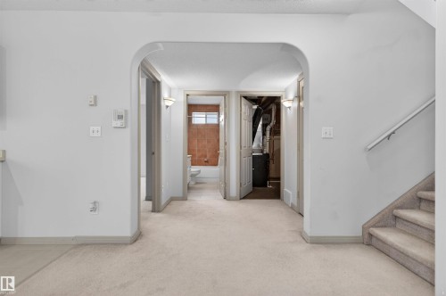 Carpeted interior area with an arched doorway leading to additional rooms - 201 Erin Ridge Drive, St. Albert, AB - Indoor Photo Showing Other Room