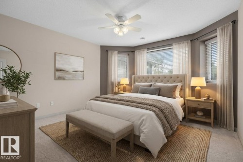 Carpeted bedroom featuring a bay window, ceiling fan, and neutral wall tones - 201 Erin Ridge Drive, St. Albert, AB - Indoor Photo Showing Bedroom