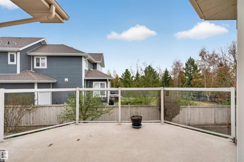 Private concrete patio featuring a glass and white-frame railing - 201 Erin Ridge Drive, St. Albert, AB - Outdoor With Exterior