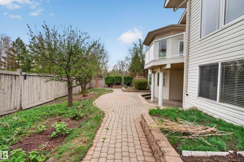 Exterior property featuring a multi-level structure with siding, an upper-level balcony with glass railing, and a lower-level covered patio - 201 Erin Ridge Drive, St. Albert, AB - Outdoor