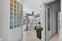 Entryway featuring light-toned tile flooring and a curved glass block wall - 