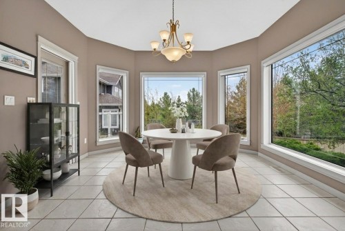 Bay window dining area featuring multiple large windows, tile flooring, and a chandelier - 201 Erin Ridge Drive, St. Albert, AB - Indoor Photo Showing Dining Room